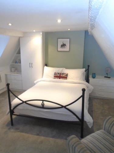 1 dormitorio con 1 cama con sábanas blancas en Kenilworth Cosy Castle View Apartment, en Kenilworth