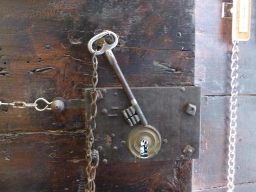 a chain attached to a wooden door with a key at Château du Grand Jardin in Valensole