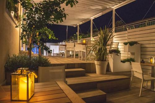 a rooftop patio at night with a table and chairs at Hotel La Baia in Diano Marina