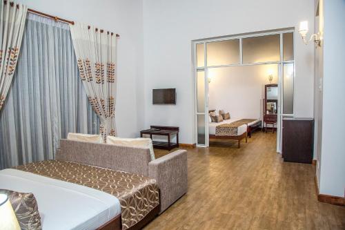 a hotel room with a bed and a couch at Villa Crystals in Colombo