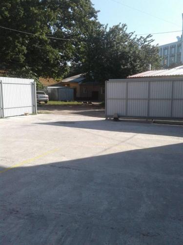 a parking lot with a white fence and a building at Centralnyi hotel in Poltava