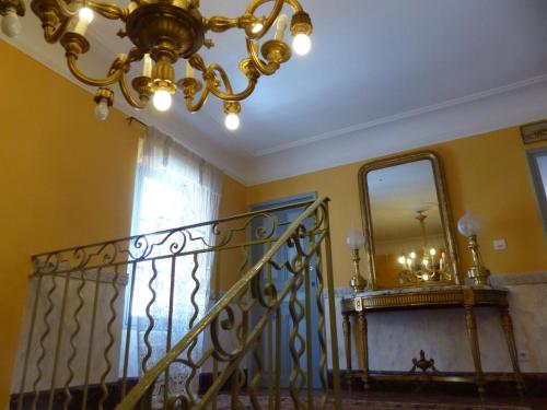 a staircase with a chandelier and a mirror at Château du Grand Jardin in Valensole