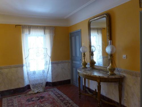 a room with a mirror and a wooden table with a table sidx sidx at Château du Grand Jardin in Valensole
