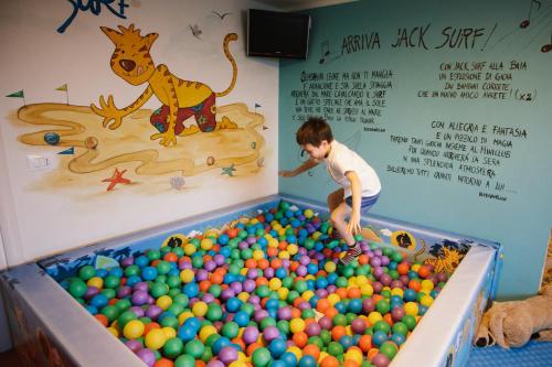a young boy playing in a large ball pool at Hotel La Baia in Diano Marina