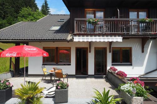 a house with an umbrella and a table and chairs at Ferienhaus Waldhof in Hermagor