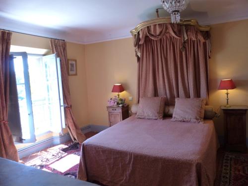 a bedroom with a large bed and a window at Château du Grand Jardin in Valensole