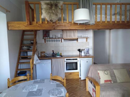 a small kitchen with a loft bed and a table at Le Pardeilhan in Luchon