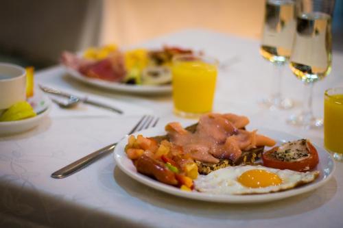 een bord met ontbijtproducten op een tafel met sinaasappelsap bij Bull Eugenia Victoria & SPA in Playa del Inglés