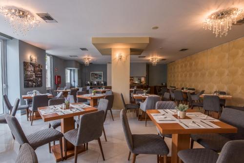 a dining room with wooden tables and chairs at Grand Olympic Hotel Loutraki in Loutraki