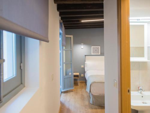 トレドにあるAldaba Apartamentosの部屋にベッドと洗面台がある寝室