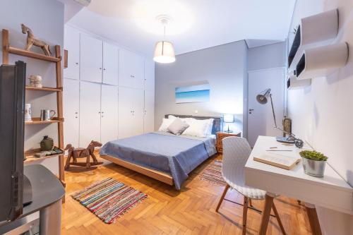 Un dormitorio con una cama y un escritorio con una computadora. en Piraeus Port Marouso, en Pireo