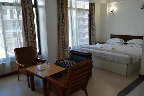 una camera con letto, tavolo e sedie di Florida Executive Inn a Dar es Salaam