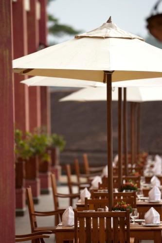 a row of tables and chairs with an umbrella at Amaya Hills Kandy in Kandy