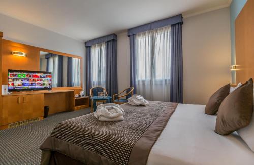 Cette chambre comprend un lit et une télévision à écran plat. dans l'établissement UNAWAY Hotel Occhiobello, à Occhiobello