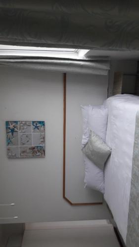 a bedroom with a bed with white sheets and a picture at Margate Boulevard 302 in Margate