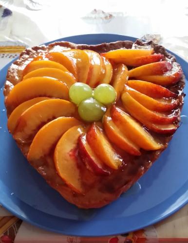 a pie with apples and grapes on a blue plate at La Casa Del Grillo 1 in Aosta