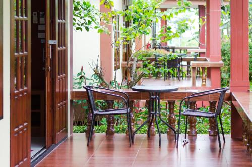 a table and chairs on a balcony with plants at Sleep In Lanta Resort in Ko Lanta