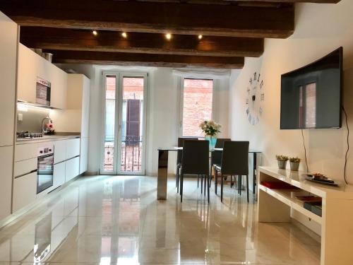 - une cuisine et une salle à manger avec une table et des chaises dans l'établissement Moderno affaccio su via Mazzini, à Ferrare