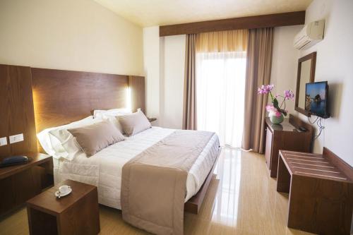 pokój hotelowy z dużym łóżkiem i oknem w obiekcie Casthotels Bristol Terme w mieście Ischia