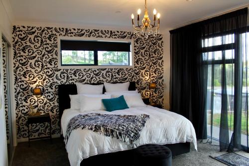 a bedroom with a bed with a black and white patterned wall at Arohanui Rural Retreat B&B in Tauranga