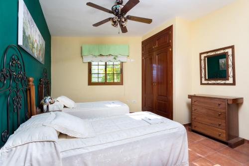 1 dormitorio con 2 camas y ventilador de techo en Casa Bora en Casas de Abajo
