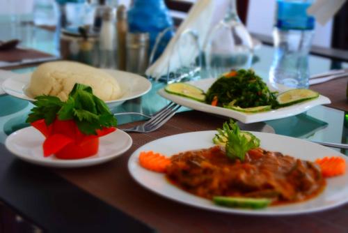 uma mesa com pratos de comida numa mesa em Florida Executive Inn em Dar es Salaam