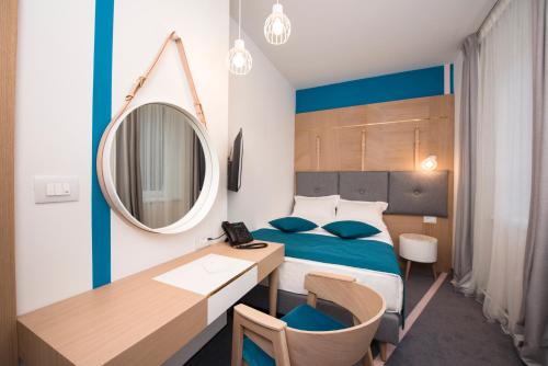 a bedroom with a bed and a desk and a mirror at City Nest Modern & Cozy Suites in Belgrade