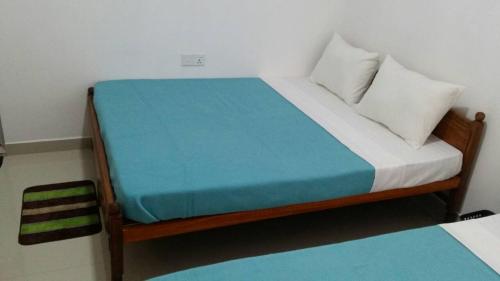 a bedroom with a bed with a blue and white mattress at Tea Breeze Motel in Adams Peak