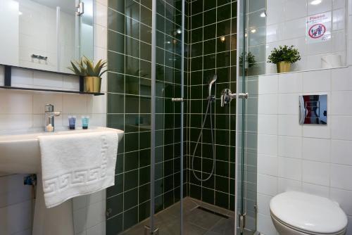 a bathroom with a green tiled shower with a toilet at The Post Hostel Jerusalem in Jerusalem