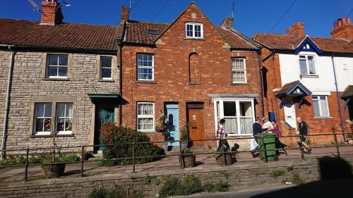 two people standing in front of a brick house at The Prophecy of Light Retreat in Glastonbury
