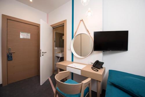 a room with a desk and a mirror and a bed at City Nest Modern & Cozy Suites in Belgrade