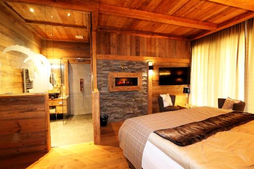 a bedroom with a large bed and a fireplace at Amber Ski-in/out Hotel & Spa in Saas-Fee