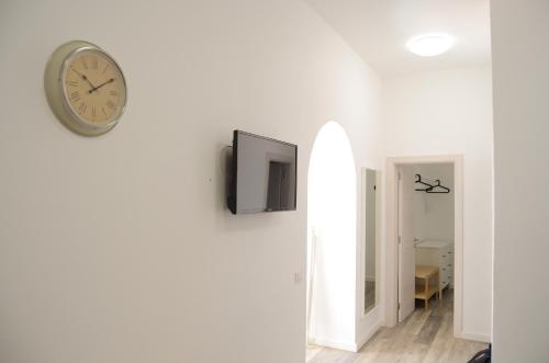 a clock on a wall with a television on it at Apartamentos El Marinero - Roque in Caleta de Sebo