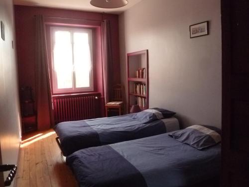 dwa łóżka w pokoju z oknem w obiekcie Gîte des bords de Rance w mieście Langrolay