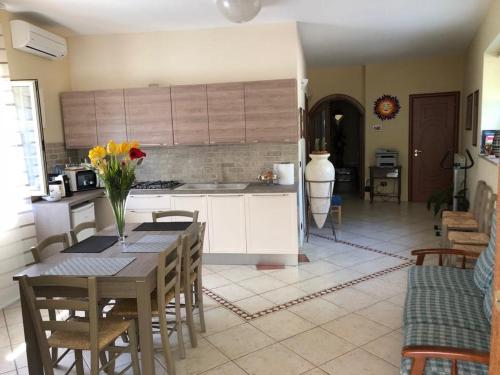 a kitchen with a table with a vase of flowers on it at B&B Primerano SP73 in Soriano Calabro