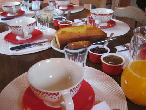 a table with a cup of tea and a piece of cake at La Glatine - Chambres d'hôtes in Frétigny