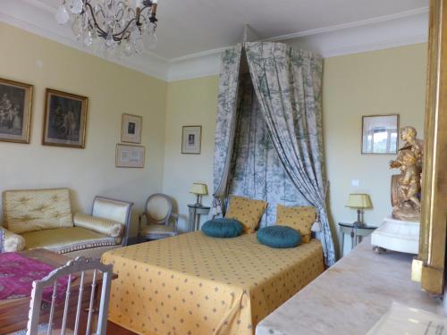 a bedroom with a bed with blue pillows on it at Château du Grand Jardin in Valensole