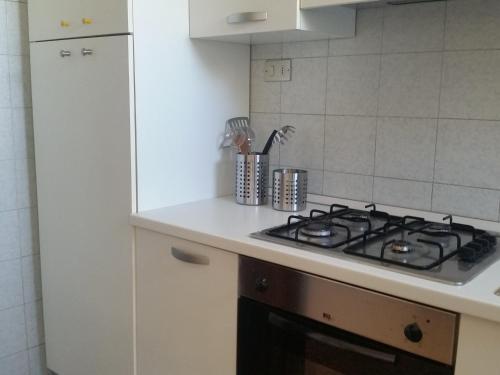 uma cozinha com fogão forno superior ao lado de um frigorífico em Nettuno Apartament em Tirrenia