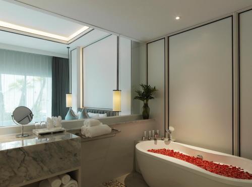 a bathroom with a tub, sink, mirror and bathtub at Chanalai Romantica Resort - Adults Only, Kata Beach - SHA Plus in Kata Beach
