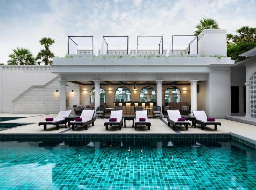 a resort with a pool and chairs and a building at Chanalai Romantica Resort - Adults Only, Kata Beach in Kata Beach