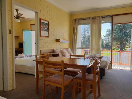 sala de estar con mesa y cama en Moon River Motor Inn, en Kempsey