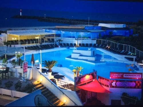 a large swimming pool in a building at night at Naturist Paradise in « Swinging Cap » in Cap d'Agde