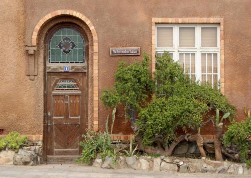 a building with a wooden door and a window at Tranquility Self Catering in Lüderitz