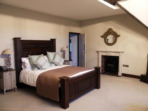 a bedroom with a large bed and a fireplace at Weston Hall in Stafford