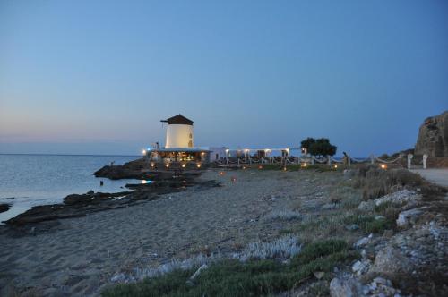 a lighthouse on the shore of a beach at night at Skyros Panorama Studios in Skiros
