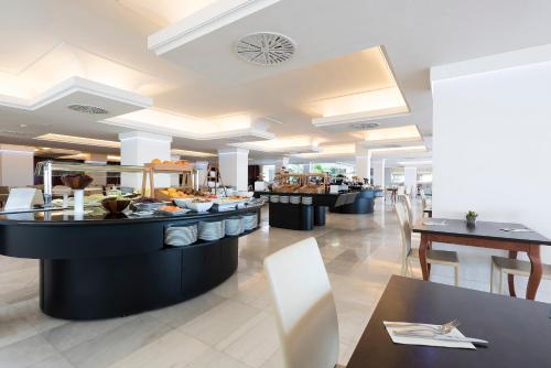 a restaurant with a buffet line with tables at Hotel Palma Bellver , Affiliated by Meliá in Palma de Mallorca