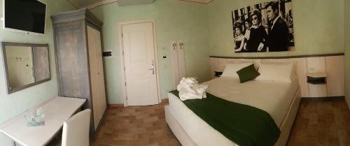 a bedroom with a bed with a cat sitting on it at Hotel Locanda Dolce Vita in San Donà di Piave