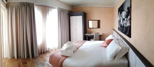 una camera con un letto bianco e una finestra di Hotel Locanda Dolce Vita a San Donà di Piave