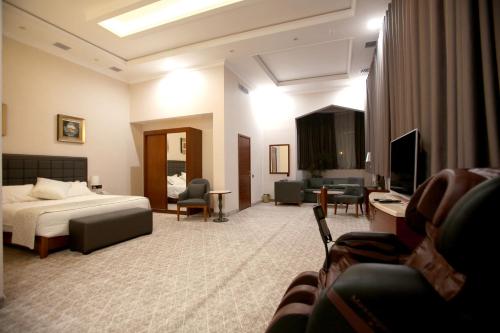a hotel room with a bed and a living room at Parliament Palace Hotel in Khujand