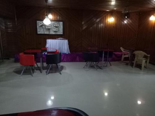 a group of tables and chairs in a barn at Hotel Kameng in Itānagar